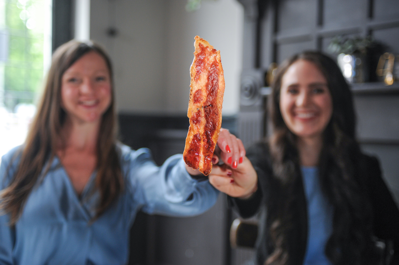 Higher Steaks head of R&D Ruth Helen Faram (L) and CEO Benjamina Bollag (R) with their lab-grown bacon prototype (Credit: Higher Steaks)